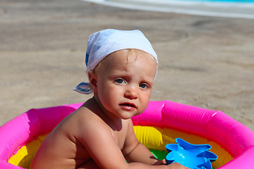 Image showing baby girl playing in a colorful kiddie pool