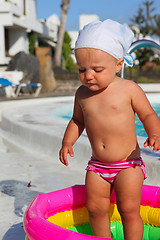 Image showing baby girl playing in a colorful kiddie pool