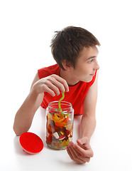 Image showing Boy with candy snake looking sideways