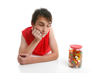Image showing Boy ponders to open jar confectionery