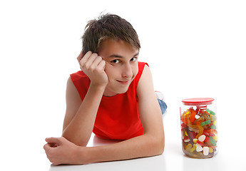 Image showing Boy beside an assortment of mixed confectionery