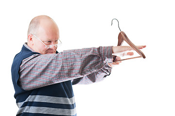 Image showing Confident man in glasses measures by hand empty cloth hanger