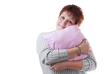 Image showing Smiling woman hugs pink pillow