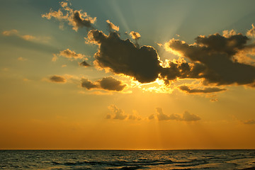 Image showing Sun behind a cloud over sea