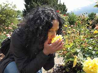 Image showing Pretty brunette smelling roses