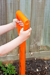 Image showing Child's hands holding the handle of a garden spade