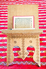 Image showing Warsh quran open on a wooden stand on a red Moroccan rug