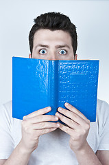 Image showing Afraid man reading a book