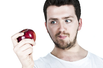 Image showing Young man straing at an apple