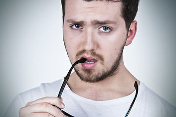 Image showing Young man holding sunglasses