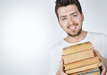 Image showing Young happy man carrying books