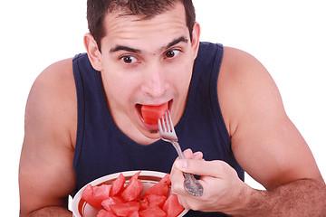 Image showing Young man eating a fresh water melon. 