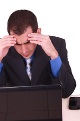 Image showing Image of businessman touching his head while looking at monitor 