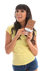 Image showing Pretty girl holding chocolate licking lips