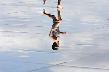 Image showing Reflection of a child running in the water.