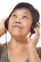 Image showing Senior woman listening to music with headphones 