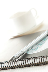 Image showing Pen on a white paper with cup of coffee