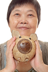 Image showing woman putting coins in small piggy bank. Selective focus, Copy s