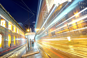 Image showing traffic light trails in the street by modern building