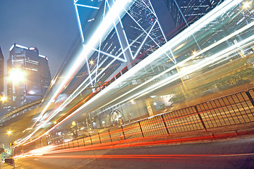 Image showing traffic light trails in the street by modern building