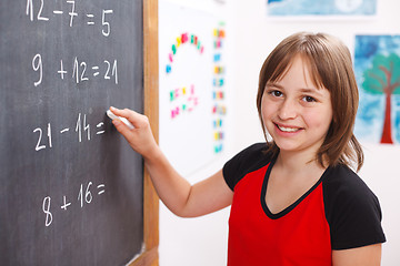 Image showing School girl writing solution on chalkboard