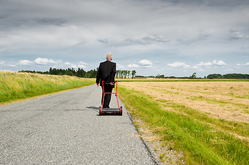 Image showing Businessman and his Lawn mower