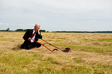 Image showing Businessman and his Lawn mower