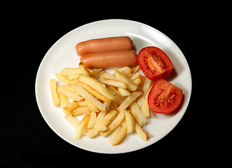 Image showing sausage served with french fries and tomatoes