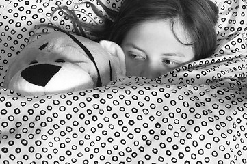 Image showing young girl in bed holding teddy bear