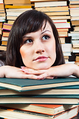 Image showing Young student girl daydreaming on books