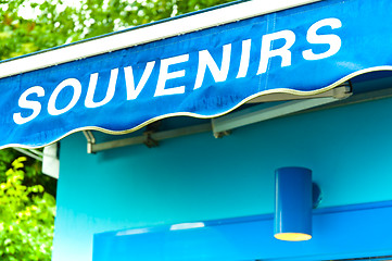 Image showing souvenirs sign on wet blue surface