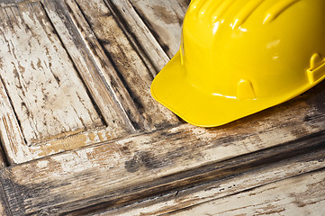 Image showing Yellow helmet on burnt wooden log