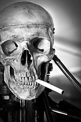 Image showing Closeup of a human skull on robot body with cigarette in mouth