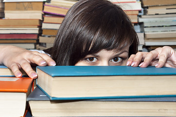 Image showing Young beautiful student girl behind books
