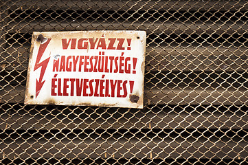 Image showing High voltage sign on rusty fence