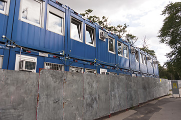 Image showing Containers piled up before fence