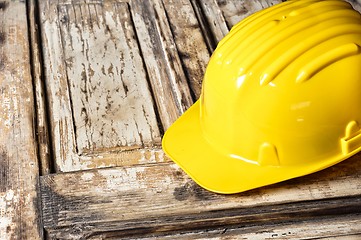 Image showing Yellow helmet on burnt wooden log