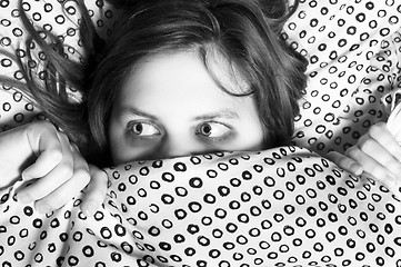 Image showing Young scared girl hiding under blanket