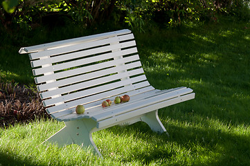 Image showing White old bench with apples