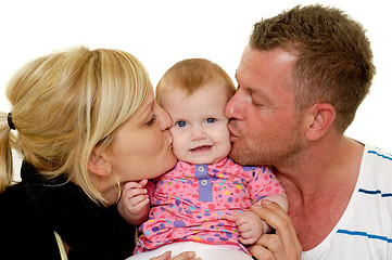 Image showing Mother and father are kissing baby