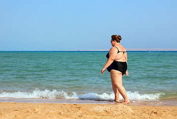Image showing overweight woman walking on beach