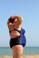 Image showing overweight woman on beach with hands up