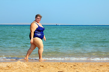 Image showing overweight woman walking on beach