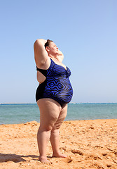 Image showing overweight woman on beach with hands up