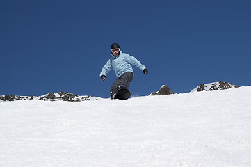 Image showing Snowboarder descends a slope