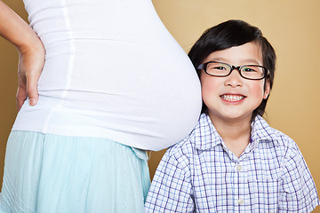 Image showing Asian boy listening to her pregnant mom belly