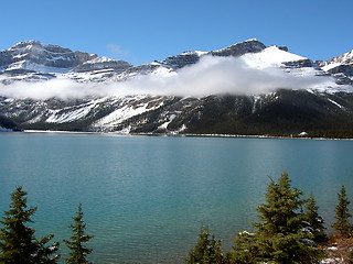 Image showing Lake with Rocky Mountain backdrop, partially obscured with a cloud band