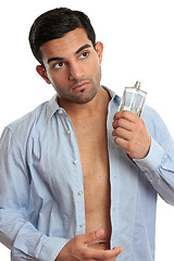 Image showing Man with cologne while dressing