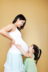 Image showing Girl kissing pregnant mother