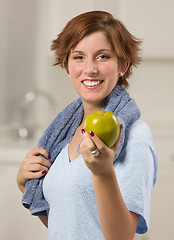 Image showing Pretty Red Haired Woman with Towel Holding Green Apple